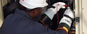 Especialista usando luvas isolantes para se proteger de tensão elétrica